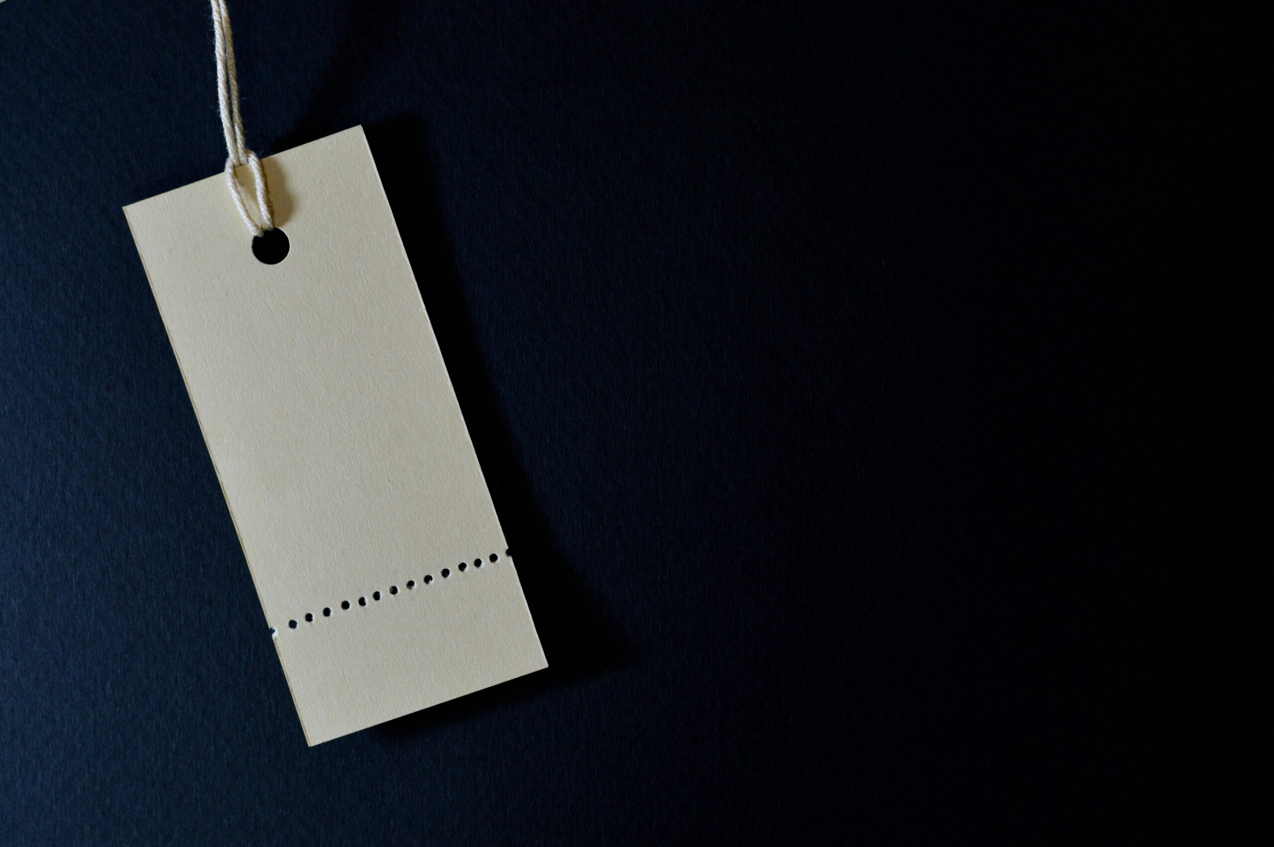 Elegant minimalist card with a string, ideal for labeling or pricing against a black background.